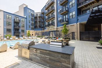 An outdoor lounge area with a grill and a pool at the bradley braddock road